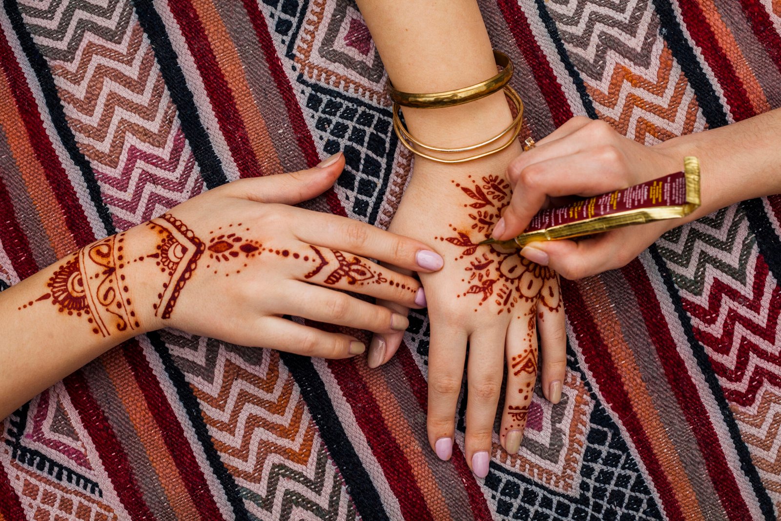 artist making mehndi womans hand bright table